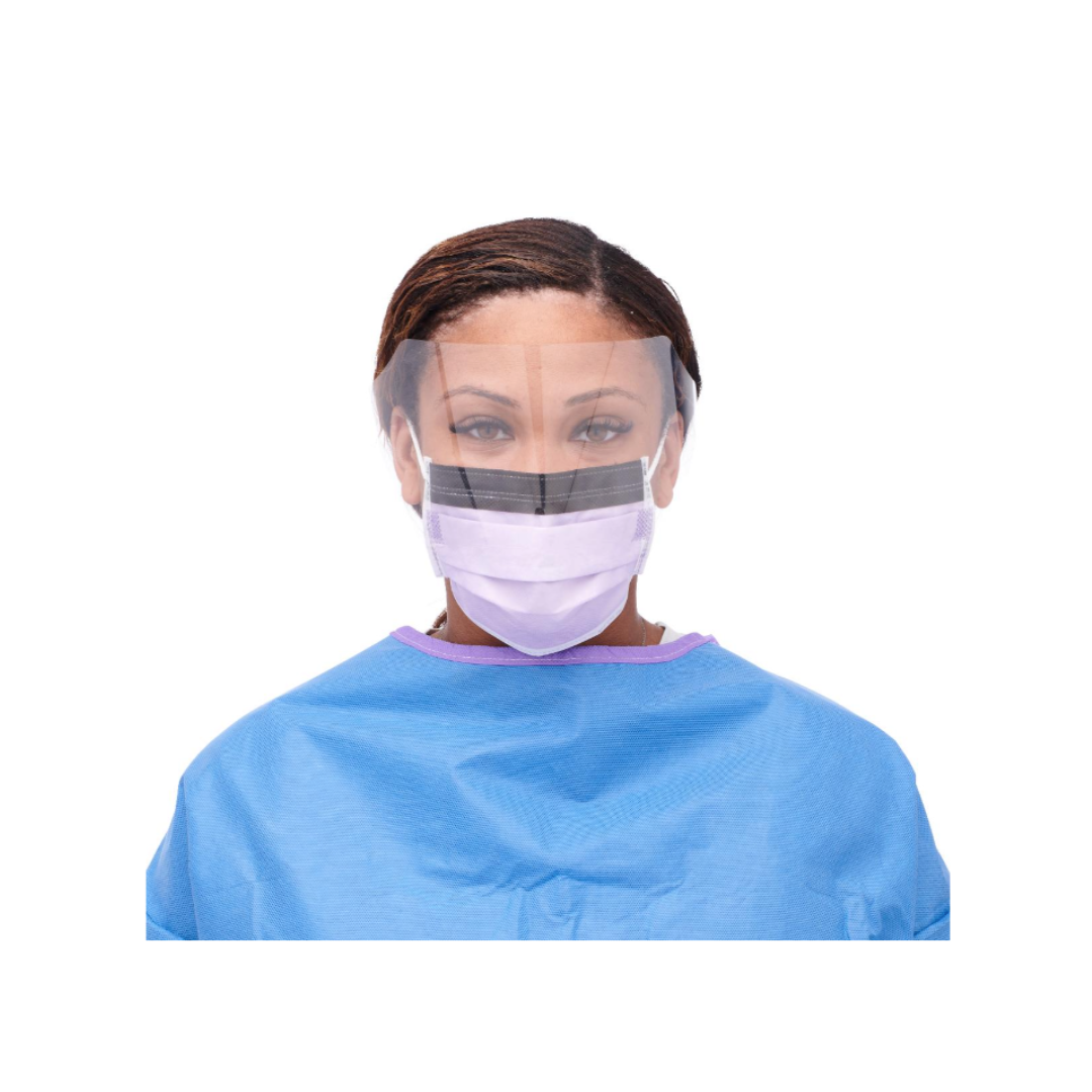 A person is wearing a blue medical gown and the Medline ASTM L3 Procedure Face Mask with Eye Shield and Ear Loops, along with a transparent face shield, facing forward against a plain white background.